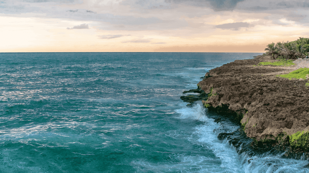 Waves breaking against rugged tropical cliffs